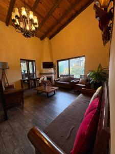 a large living room with couches and a chandelier at Cabañas Puerta del Bosque núm 2 in Mazamitla