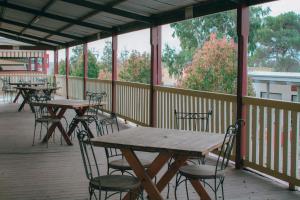 a row of tables and chairs on a deck at Balcony On Sixth Lodge in Murray Bridge