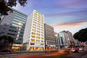 a tall white building on a city street with cars at Evergreen Laurel Hotel Taipei in Taipei