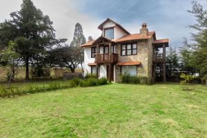 an old stone house with a balcony on a yard at Cabaña El Sitio in Huasca de Ocampo