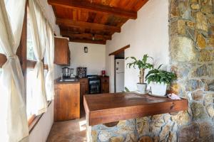 a kitchen with a table and a stone wall at Cabaña El Sitio in Huasca de Ocampo