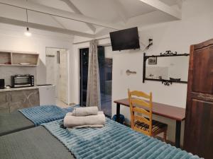 a room with a kitchen and a table and a bed at Aloe Haven in Lichtenburg