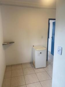 a small refrigerator in a room with a tile floor at Cabana Maktub in Uruçuca