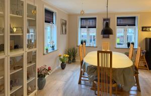 a dining room with a table and chairs and windows at Nice Home In Ansager With Wifi in Ansager