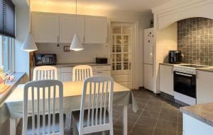 a kitchen with white cabinets and a table and chairs at Nice Home In Ansager With Wifi in Ansager