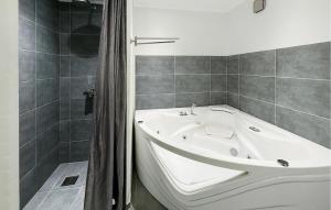 a white bath tub in a bathroom with a shower at Nice Home In Ansager With Wifi in Ansager +18 photos