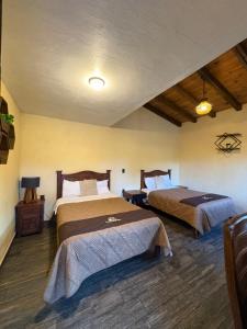 a bedroom with two beds in a room at Cabañas Puerta del Bosque núm 2 in Mazamitla