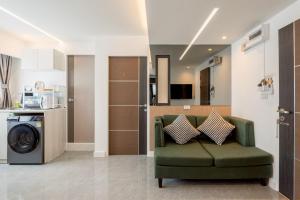 a living room with a green couch and a kitchen at CJ ELAND Sukhumvit36 BTS Thonglor in Klong Toi