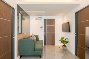 a living room with a green chair and a television at CJ ELAND Sukhumvit36 BTS Thonglor in Klong Toi