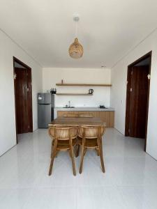 a kitchen with a wooden table and two chairs at Alijul Private villa in Munggu +1 photo