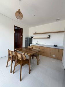 a kitchen with a wooden table and two chairs at Alijul Private villa in Munggu
