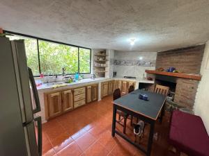 a kitchen with a table in the middle of it at Hospedaje Las Bromelias - Departamento Familiar in Papallacta