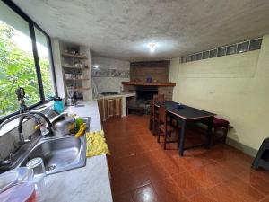 a kitchen with a sink and a table in it at Hospedaje Las Bromelias - Departamento Familiar in Papallacta +9 photos