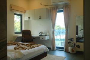 a bedroom with a bed and a chair and a window at Turiya Retreat in Auroville +56 photos