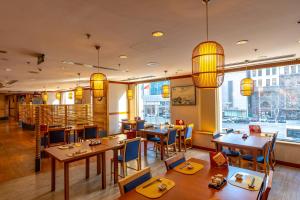 a restaurant with wooden tables and chairs and large windows at Shangri-La Dalian in Dalian