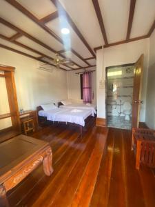 a bedroom with a bed and a wooden floor at Phonyeng Guest house in Ban Mouang