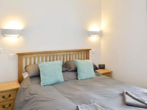 a bed with two blue pillows on top of it at Anchor's Away in Filey