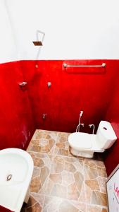 a red bathroom with a toilet and a bidet at Willow Nest Inn in Mahiyangana +47 photos