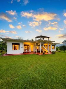 a house with a green lawn in front of it at Willow Nest Inn in Mahiyangana