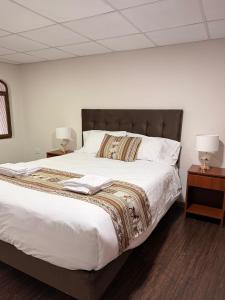 a bedroom with a large white bed with two night stands at Posada Del Corregidor in Cajamarca +28 photos