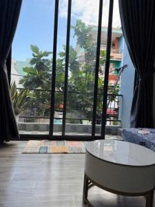 a living room with a table and a large window at THHomestay in Danang