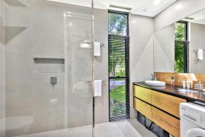 a bathroom with a shower with a glass door at Under the Pecans - 2BR Retreat with Peaceful Scenic Views in Woombye +26 photos
