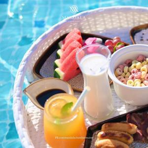 a basket of food with fruit and a drink at Apec Mandala Imperial Ocean Tower Mui Ne in Mui Ne