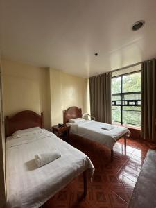 a hotel room with two beds and a window at Hotel 45 Extension in Baguio