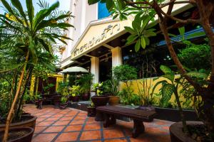 a patio with plants and a bench in front of a building at Sathorn Garden View in Bangkok