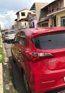 a red car parked on the side of a street at Hostel Manga Rosa Stm in Santarém +10 photos