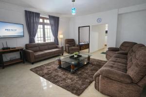 a living room with two couches and a tv at Kandy Royal Resort in Kandy