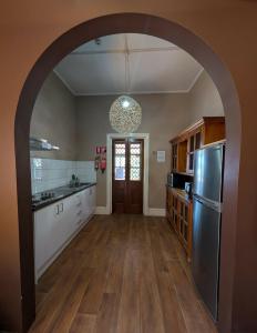 an archway in a kitchen with a stainless steel refrigerator at Balcony On Sixth Lodge in Murray Bridge +5 photos