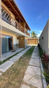 a house with a walkway next to a building at Duplex 2 Suites Pool Barbecue Air in Santa Cruz Cabrália