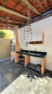 a kitchen with a counter and a sink in a room at Duplex 2 Suites Pool Barbecue Air in Santa Cruz Cabrália