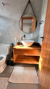 a bathroom with a sink and a mirror at Duplex 2 Suites Pool Barbecue Air in Santa Cruz Cabrália