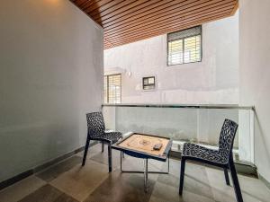 two chairs and a table in a room with a window at SeaLara Resorts in Covelong