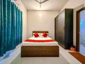a bedroom with a bed with red pillows on it at SeaLara Resorts in Covelong +30 photos