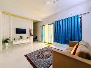 a living room with a couch and a tv at SeaLara Resorts in Covelong