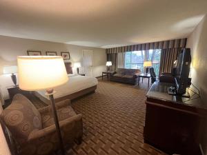 a hotel room with a bed and a desk with a lamp at Derby Hotel & Suites in Clarksville