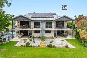an aerial view of a house with solar panels on the roof at Amarco Spacious Riverfront with Sunset Views in Iluka