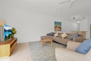 a living room with a couch and a tv at 1 Riverside in Noosaville