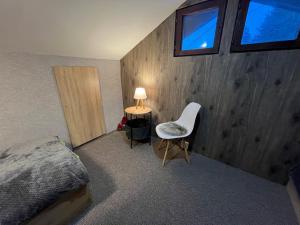 a bedroom with a bed and a chair and a lamp at Delight House in Samokov