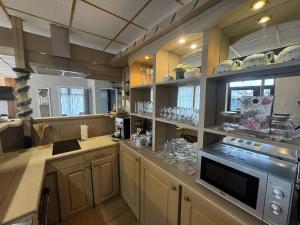 a large kitchen with wooden cabinets and a microwave at Delight House in Samokov