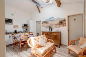 a living room with chairs and a table and a kitchen at Logis des Lauriers Roses in Marennes