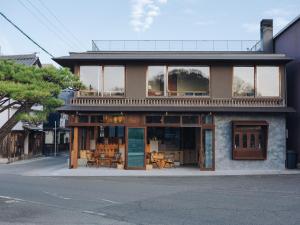 ein Gebäude mit Tischen und Stühlen an einer Straße in der Unterkunft SOIL Setoda in Onomichi