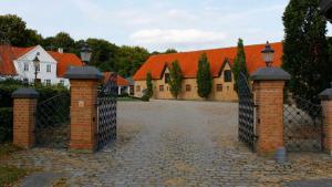 a gate to a house with an orange roof at Louiselund Bed & Breakfast in Haderslev