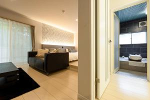 a bedroom with a couch and a bed in a room at グランコテージベンガルの森 in Nasu