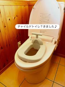 a toilet with the lid up in a bathroom at らくがきシーサイド牛窓 in Setouchi +51 photos