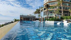 a large swimming pool next to a building at Mandala Casa del Sol Mũi Né in Mui Ne
