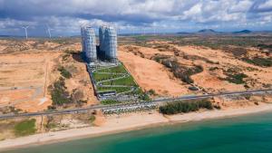 an aerial view of a building next to the ocean at Mandala Casa del Sol Mũi Né in Mui Ne